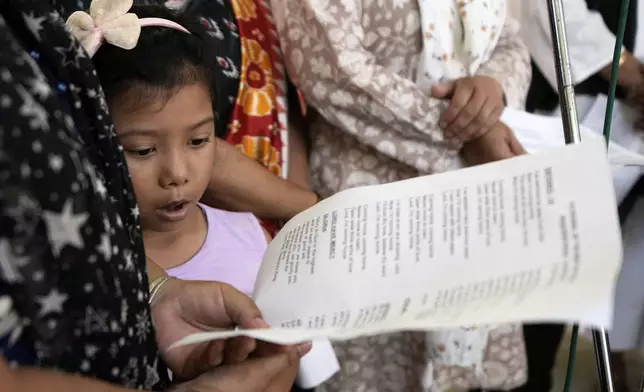 A little Catholic girl sings in the choir as during a service for the late Pope Francis at the Cathedral of The Most Holy Rosary, in Kolkata, India, Saturday, April 26, 2025. (AP Photo/Bikas Das)