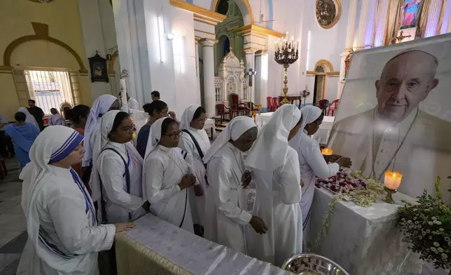 Catholic nuns pay tribute at a portrait of the late Pope Francis after a service at the Cathedral of The Most Holy Rosary, in Kolkata, India, Saturday, April 26, 2025. (AP Photo/Bikas Das)