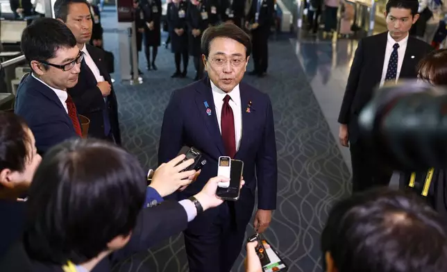 Japan's chief trade negotiator and Economic Revitalization Minister Ryosei Akazawa, center, speaks to the reporters before this departure for the U.S., at Haneda airport in Tokyo, Wednesday, April 16, 2025. (Kyodo News via AP)