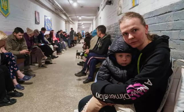 A mother comforts her son in a school basement being used as a shelter after a Russian airstrike on a residential neighborhood in Kyiv, Ukraine, on Thursday, April 24, 2025. (AP Photo/Evgeniy Maloletka)