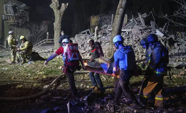 Rescue workers carry an injured victim on a stretcher in front of a house that was destroyed by a Russian strike in a residential neighbourhood in Kyiv, Ukraine, on Thursday, April 24, 2025. (AP Photo/Evgeniy Maloletka)