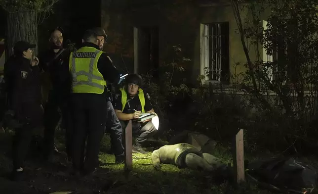 EDS NOTE: GRAPHIC CONTENT - Police officers inspect a dead body after a Russian ballistic missile attack in Kyiv, Ukraine, early Thursday, April 24, 2025. (AP Photo/Efrem Lukatsky)