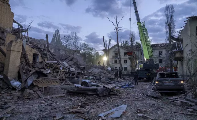 Rescue workers clear the rubble after a Russian strike in a residential neighborhood in Kyiv, Ukraine, Thursday, April 24, 2025. (AP Photo/Alex Babenko)