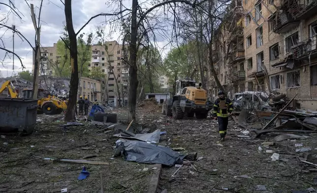 A rescue worker passes the body of a victim after a Russian strike in a residential neighborhood in Kyiv, Ukraine, Thursday, April 24, 2025. (AP Photo/Alex Babenko)