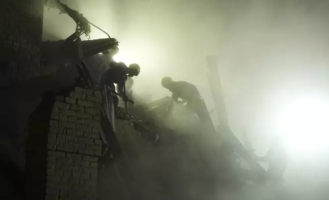 Ukrainian searchers clear the rubble after a Russian ballistic missile attack in Kyiv, Ukraine, early Thursday, April 24, 2025. (AP Photo/Efrem Lukatsky)