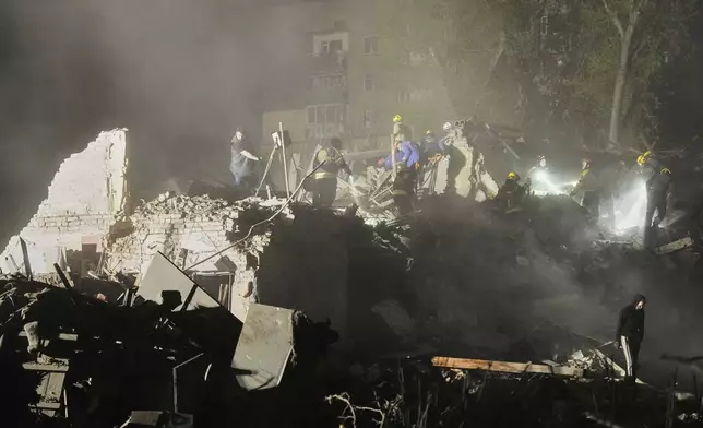 Ukrainian searchers clear the rubble after a Russian ballistic missile attack in Kyiv, Ukraine, early Thursday, April 24, 2025. (AP Photo/Efrem Lukatsky)