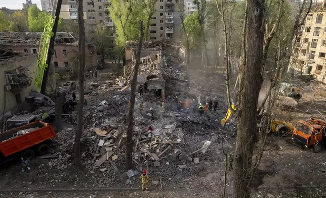 Rescue workers clear the rubble after a Russian strike in a residential neighborhood in Kyiv, Ukraine, Thursday, April 24, 2025. (AP Photo/Alex Babenko)
