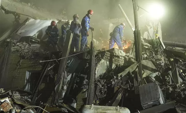 Ukrainian searchers clear the rubble after a Russian ballistic missile attack in Kyiv, Ukraine, early Thursday, April 24, 2025. (AP Photo/Efrem Lukatsky)