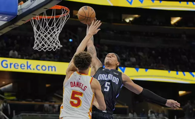 Orlando Magic forward Paolo Banchero, right, tries to shoot over Atlanta Hawks guard Dyson Daniels, left, during the second half of an NBA basketball game, Tuesday, April 8, 2025, in Orlando, Fla. (AP Photo/John Raoux)