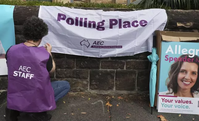 An election official hangs a sign outside a polling place as early voting begins in Sydney, Tuesday, April 22, 2025, for a national election to be held on May 3. (AP Photo/Mark Baker)