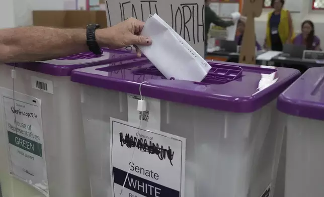 A ballot is dropped into a a box as early voting begins in Sydney, Tuesday, April 22, 2025, for a national election to be held on May 3. (AP Photo/Mark Baker)
