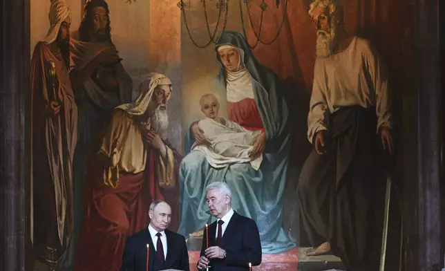 Russian President Vladimir Putin, left, and Moscow Mayor Sergei Sobyanin attend the Orthodox Easter service at Christ the Saviour Cathedral in Moscow, Russia, Saturday, April 19, 2025. (Ramil Sitdikov/Sputnik/Kremlin Pool Photo via AP)