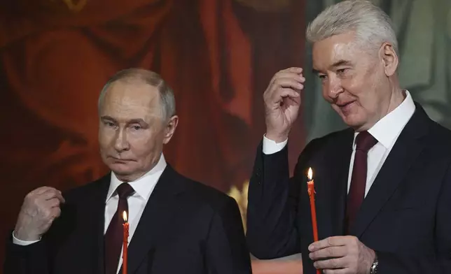 Russian President Vladimir Putin, left, and Moscow Mayor Sergei Sobyanin attend the Orthodox Easter service at Christ the Saviour Cathedral in Moscow, Russia, Saturday, April 19, 2025. (Ramil Sitdikov/Sputnik/Kremlin Pool Photo via AP)
