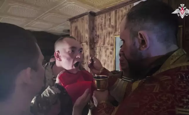 In this image from video distributed by the Russian Defense Ministry Press Service on Sunday, April 20, 2025, a Russian soldier gets an communion after a religion service on eve of Orthodox Easter at an unspecified location in Ukraine. (Russian Defense Ministry Press Service via AP)