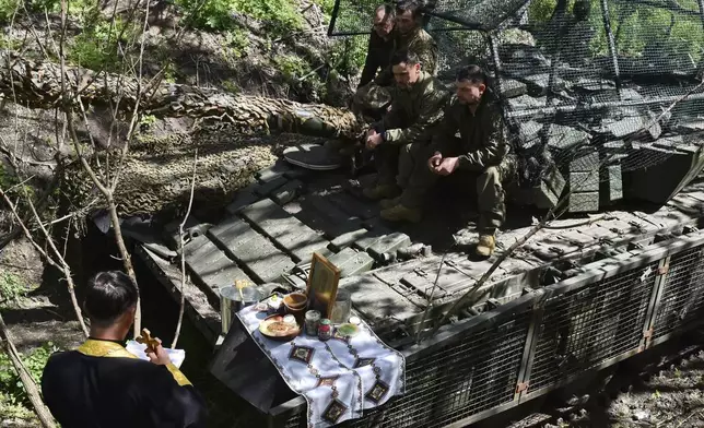 In this photo provided by Ukraine's 65th Mechanized Brigade press service, a chaplain conducts an Easter service for soldiers to mark Easter on the frontline in the Zaporizhzhia region, Ukraine, Sunday, April 20, 2025. (Andriy Andriyenko/Ukraine's 65th Mechanized Brigade via AP)
