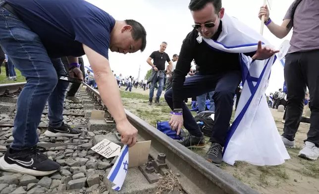 People place massages while attending the "March of the Living", the annual Holocaust remembrance event in memory of the six million Holocaust victims, at the former Nazi German death camp of Auschwitz-Birkenau in Oswiecim, Poland, Thursday, April 24, 2025. (AP Photo/Czarek Sokolowski)