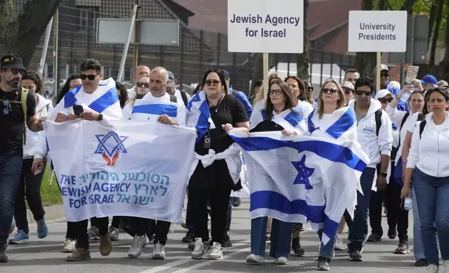 People attend the "March of the Living", the annual Holocaust remembrance event in memory of the six million Holocaust victims, at the former Nazi German death camp of Auschwitz-Birkenau in Oswiecim, Poland, Thursday, April 24, 2025. (AP Photo/Czarek Sokolowski)