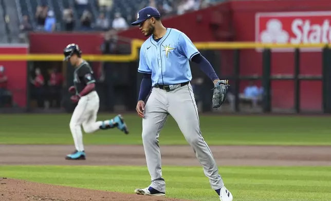 Tampa Bay Rays starting pitcher Taj Bradley, right, walks back to the pitcher's mound after giving up a home run to Arizona Diamondbacks' Corbin Carroll, left, during the first inning of a baseball game Wednesday, April 23, 2025, in Phoenix. (AP Photo/Ross D. Franklin)