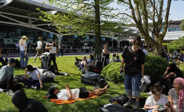 Passengers wait outside Lisbon Airport during a nationwide power outage in Lisbon, Monday, April 28, 2025. (AP Photo/Armando Franca)