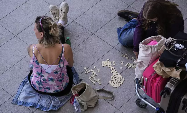 Passengers wait outside Lisbon Airport during a nationwide power outage in Lisbon, Monday, April 28, 2025. (AP Photo/Armando Franca)