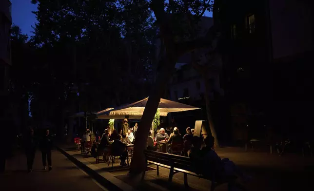 Customers dine in a restaurant illuminated by a generator during a blackout in Barcelona, Spain, Monday, April 28, 2025. (AP Photo/Emilio Morenatti)