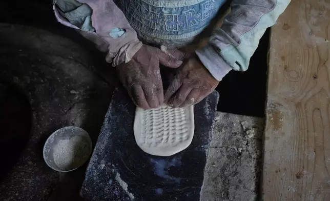A Kashmiri baker works inside his shop in Srinagar, Indian controlled Kashmir, Thursday, April 24, 2025. (AP Photo/Mukhtar Khan)