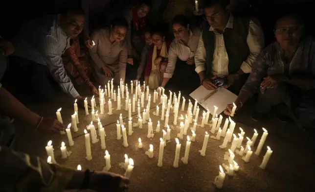 People place candles after a march against the killing of tourists by militants near Pahalgam in Indian controlled Kashmir, in Ahmedabad, India, Thursday, April 24, 2025. (AP Photo/Ajit Solanki)