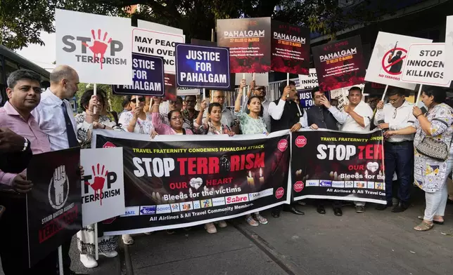 Members of airlines and tourism facility providers walk in a procession with posters during a protest against the killing of tourists by militants near Pahalgam in Indian controlled Kashmir, in Kolkata, India, Thursday, April 24, 2025. (AP Photo/Bikas Das)
