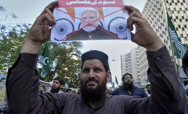 A supporter of the Pakistan Murkazi Muslim League party holds a crossed poster of Indian Prime Minister Narendra Modi with the words 'Modi butcher" during a demonstration against the suspension of water-sharing treaty by India with Pakistan, in Karachi, Pakistan Thursday, April 24, 2025. (AP Photo/Fareed Khan)