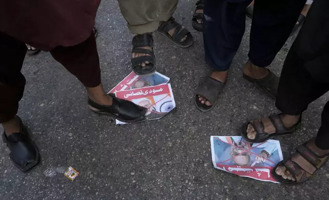 Supporters of the Pakistan Murkazi Muslim League party stand over the crossed posters of Indian Prime Minister Narendra Modi and Indian Minister of Home Affairs Amir Shah during a demonstration against the suspension of water-sharing treaty by India with Pakistan, in Karachi, Pakistan Thursday, April 24, 2025. (AP Photo/Fareed Khan)