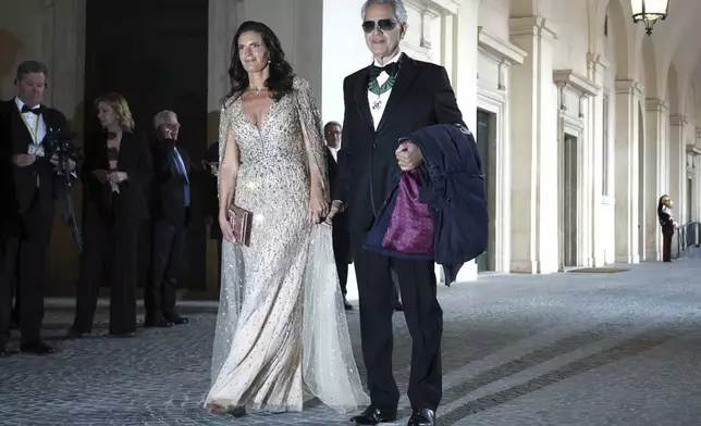 Tenor Andrea Bocelli, right, poses with his wife Veronica Berti as they arrive for an official dinner with King Charles III and Queen Camilla at the Quirinale Presidential Palace to meet with Italy's President Sergio Mattarella, in Rome, Wednesday, April 9, 2025. (AP Photo/Andrew Medichini)