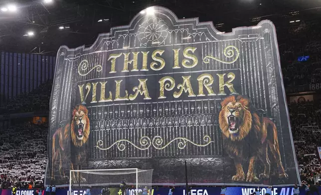 Fans of Villa display a sign before the Champions League quarterfinal second leg soccer match between Aston Villa and Paris Saint-Germain at Villa Park stadium, Birmingham, England, Tuesday, April 15, 2025. (AP Photo/Kirsty Wigglesworth)