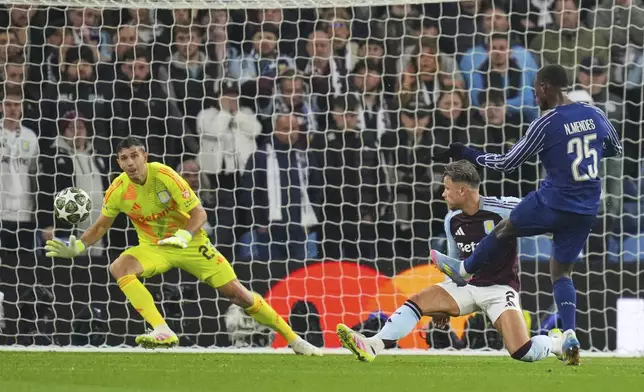 PSG's Nuno Mendes, right, scores his side's second goal during the Champions League quarterfinal second leg soccer match between Aston Villa and Paris Saint-Germain at Villa Park stadium, Birmingham, England, Tuesday, April 15, 2025. (AP Photo/Kirsty Wigglesworth)
