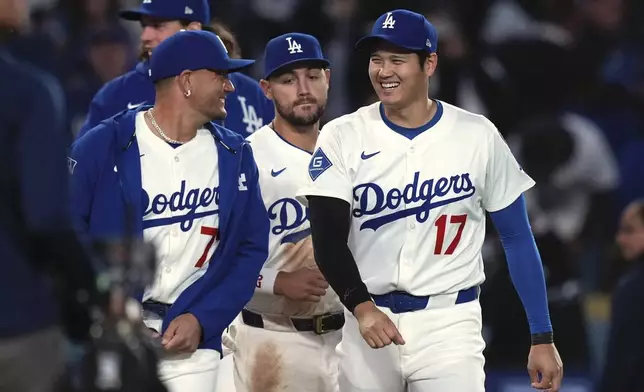 Los Angeles Dodgers' Miguel Rojas, left, and Shohei Ohtani chat after the Los Angeles Dodgers defeated the Colorado Rockies 8-7 in a baseball game Wednesday, April 16, 2025, in Los Angeles. (AP Photo/Mark J. Terrill)