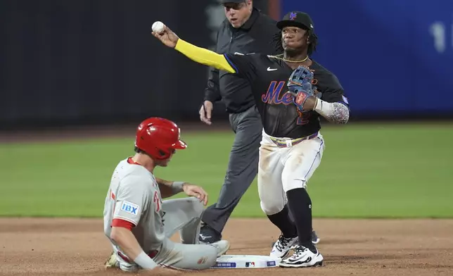 New York Mets' Luisangel Acuña, right, throws to first base after forcing out Philadelphia Phillies' Max Kepler during the fourth inning of a baseball game Tuesday, April 22, 2025, in New York. (AP Photo/Frank Franklin II)
