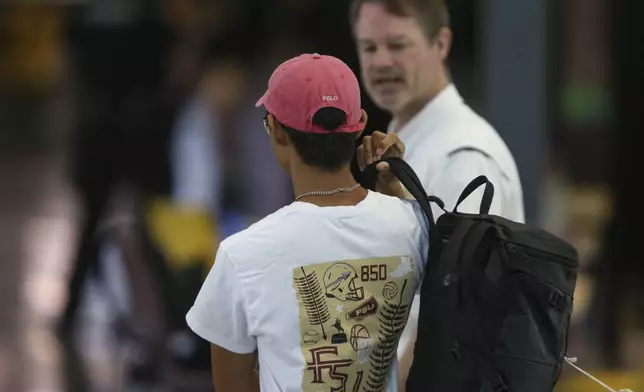 Student Ethan Cheng retrieves his sunglasses, computer and backpack that he left inside the Florida State Student Union building at the time of the shooting, in Tallahassee, Fla., Friday, April 18, 2025. (AP Photo/Gary McCullough)