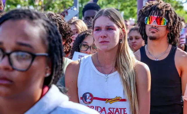 A student mourns during a vigil on the Florida State campus at Langford Green, Tallahassee, Fla., Friday, April 18, 2025. (AP Photo/Gary McCullough)