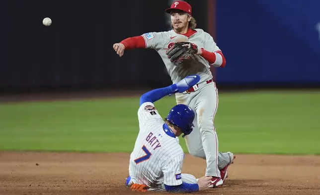 Philadelphia Phillies' Bryson Stott, right, throws to first base after forcing out New York Mets' Brett Baty (7) during the seventh inning of a baseball game Monday, April 21, 2025, in New York. (AP Photo/Frank Franklin II)