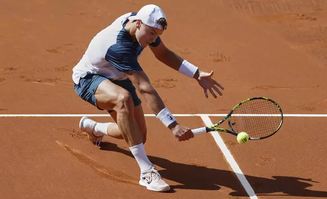 Denmark's Holger Rune returns to Spain's Carlos Alcaraz during the ATP Barcelona Open tennis final in Barcelona, Spain, Sunday, April 20, 2025. AP Photo/Joan Monfort)