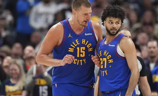Denver Nuggets center Nikola Jokic, left, confers with guard Jamal Murray, right, in the second half of Game 1 of an NBA first-round playoff series against the Los Angeles Clippers, Saturday, April 19, 2025, in Denver. (AP Photo/David Zalubowski)