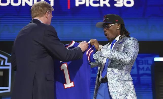Kentucky cornerback Maxwell Hairston, right, celebrates with NFL Commissioner Roger Goodell after being chosen by the Buffalo Bills with the 30th overall pick during the first round of the NFL football draft, Thursday, April 24, 2025, in Green Bay, Wis. (AP Photo/Jeff Roberson)