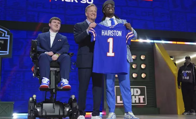 Kentucky cornerback Maxwell Hairston, right, poses with NFL Commissioner Roger Goodell , center, and Tommy Parzymieso after being chosen by the Buffalo Bills with the 30th overall pick during the first round of the NFL football draft, Thursday, April 24, 2025, in Green Bay, Wis. (AP Photo/Jeff Roberson)