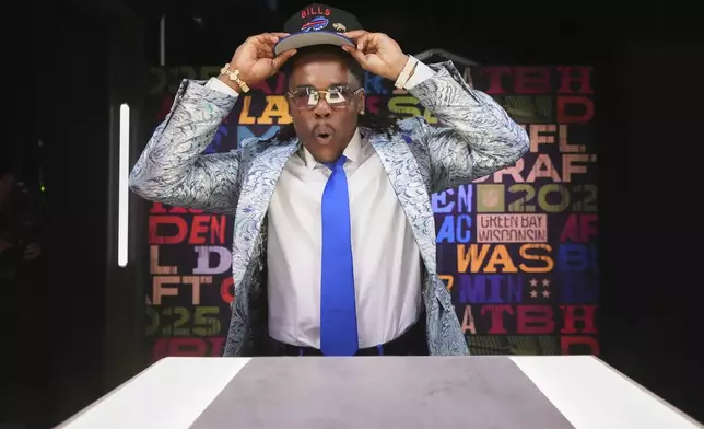 Kentucky cornerback Maxwell Hairston puts on a hat after being chosen by the Buffalo Bills with the 30th overall pick during the first round of the NFL football draft, Thursday, April 24, 2025, in Green Bay, Wis. (AP Photo/Jeff Roberson)