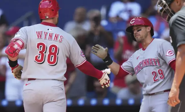 Cincinnati Reds' Austin Wynns (38) is greeted by TJ Friedl (29) after hitting a solo home run during the third inning of a baseball game against the Miami Marlins, Wednesday, April 23, 2025, in Miami. (AP Photo/Lynne Sladky)