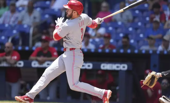 Cincinnati Reds' Gavin Lux (2) follows through on a RBI single to score TJ Friedl during the first inning of a baseball game against the Miami Marlins, Wednesday, April 23, 2025, in Miami. (AP Photo/Lynne Sladky)