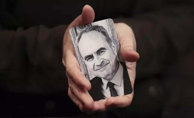 Erica Weeder holds a photo of her husband, John Kezdy, in her hands before she goes up to give her impact statement about the two of them being shot by Robert E. Crimo III during his sentencing hearing at the Lake County Courthouse, in Waukegan, Ill., Thursday, April 24, 2025. (Stacey Wescott/Chicago Tribune via AP, Pool)