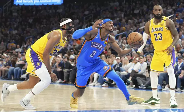 Oklahoma City Thunder guard Shai Gilgeous-Alexander, middle, drives past Los Angeles Lakers guard Jordan Goodwin, left, and forward LeBron James, right, during the second half of an NBA basketball game, Tuesday, April 8, 2025, in Oklahoma City. (AP Photo/Kyle Phillips)
