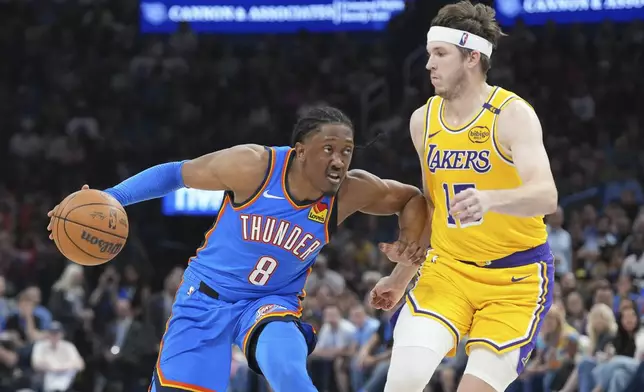 Oklahoma City Thunder forward Jalen Williams, left, drives past Los Angeles Lakers guard Austin Reaves, right, during the second half of an NBA basketball game, Tuesday, April 8, 2025, in Oklahoma City. (AP Photo/Kyle Phillips)