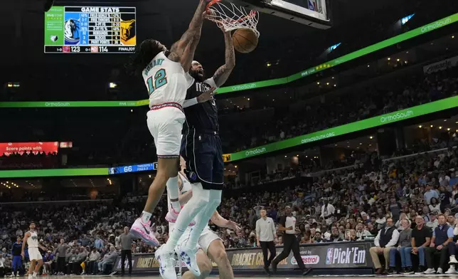 Dallas Mavericks forward Anthony Davis, right, dunks the ball past Memphis Grizzlies guard Ja Morant (12) during the second half of an NBA play-in tournament basketball game Friday, April 18, 2025, in Memphis, Tenn. (AP Photo/George Walker IV)
