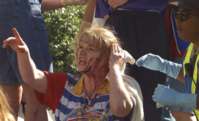 FILE - An unidentified woman calls out to friends as she waits for treatment following a bomb blast at the Alfred P. Murrah Federal Building in downtown Oklahoma City, April 19, 1995. (AP Photo/David Longstreath, File)
